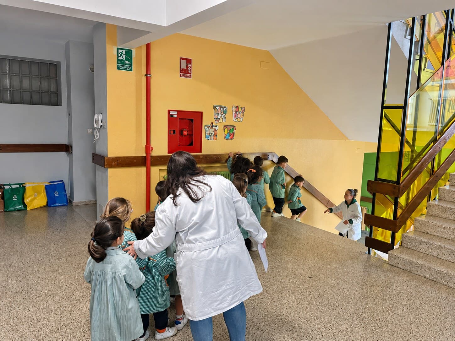 Monitora guiando a un grupo de escolares durante un simulacro de evacuación